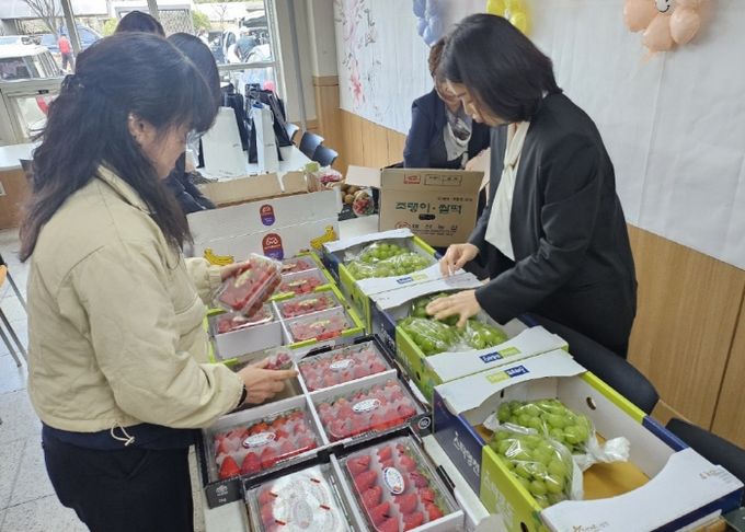 과일봉사단이 어르신들에게 나눠드릴 과일을 담고 있다.