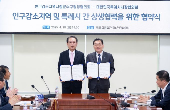 이재준 수원시장(오른쪽)과 송인헌 괴산군수가 협약 체결 후 기념촬영을 하고 있다.