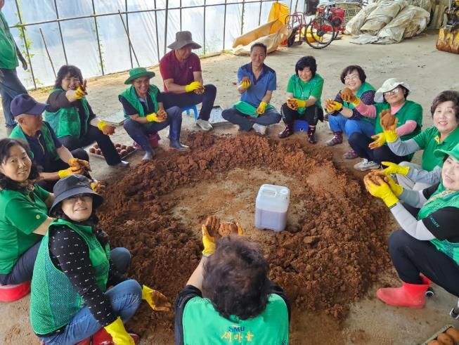 청양군 새마을회 읍면 협의회장과 부녀회장 등 30여 명이 EM 흙공을 만들고 있는 모습