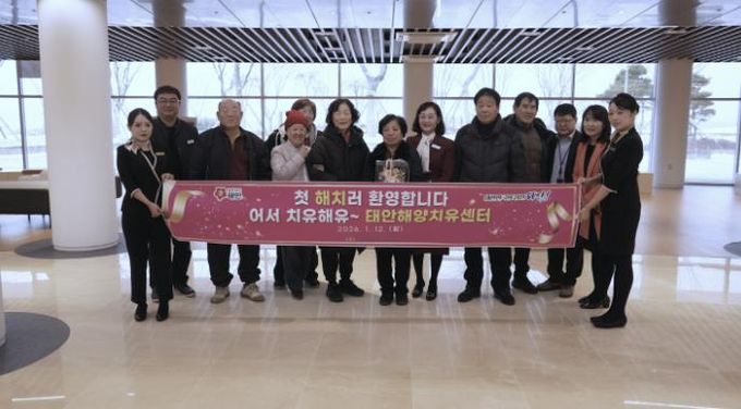 정식 운영 첫 방문객에게 꽃다발과 상용품 세트를 증정하는 모습