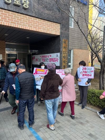 23일 하남시 보건소 직원들이 미사강변13단지 아파트 경로당 앞에서 결핵 예방 홍보물을 들고 있다.