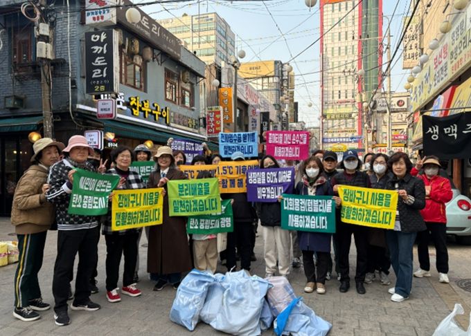 지난 25일 광명사거리 먹자골목에서 '기후의병 줍킹데이'를 진행하고 기념사진을 촬영하고 있다.