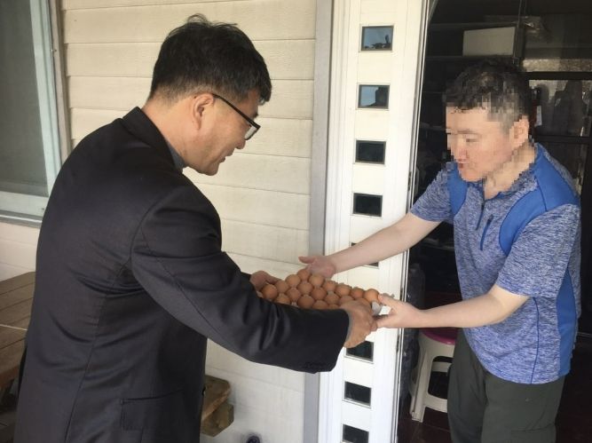 이정진 선장면장이 지역 내 취약계층 가구를 방문해 계란을 전달하며 안부를 확인하고 있다.